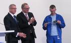 Krzysztof Zuzak i Rainer Martens przekazli symboliczny klucz do zakłądu jednemu z nowych pracowników. Fot. Adam Cyło