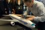 Kapitan Tadeusz Wrona składa autograf na modelu Boeinga. Fot. Youtube