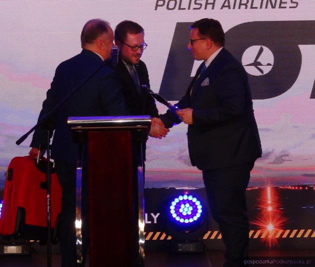 Od lewej: Zbigniew Halat i Michał Tabisz wręczają stauetkę prezesowi PLL Lot Rafałowi Milczarskiemu. Oprócz stauetki także czerwona walizka od Baltony