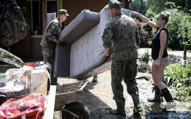 Zołnierze WOT pomagają sprzątać rzeczy po powodzi. Fot. WOT