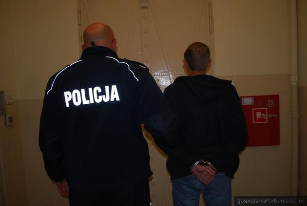 Jeden z zatrzymanych wprowadzany do celi. Fot. policja